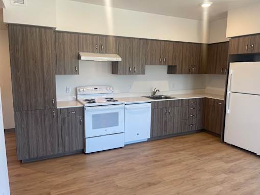A kitchen with white appliances and wooden cabinets.