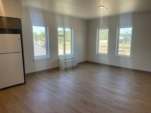 A kitchen with a white refrigerator and wooden floors.