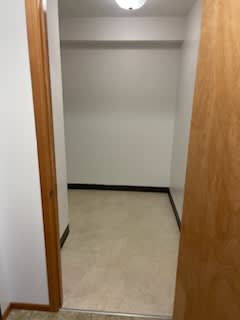 A white wall with a brown door.