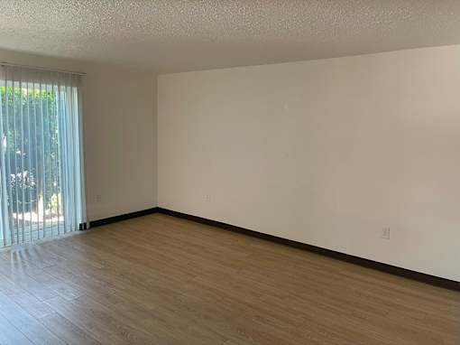 A room with wooden flooring and white walls.