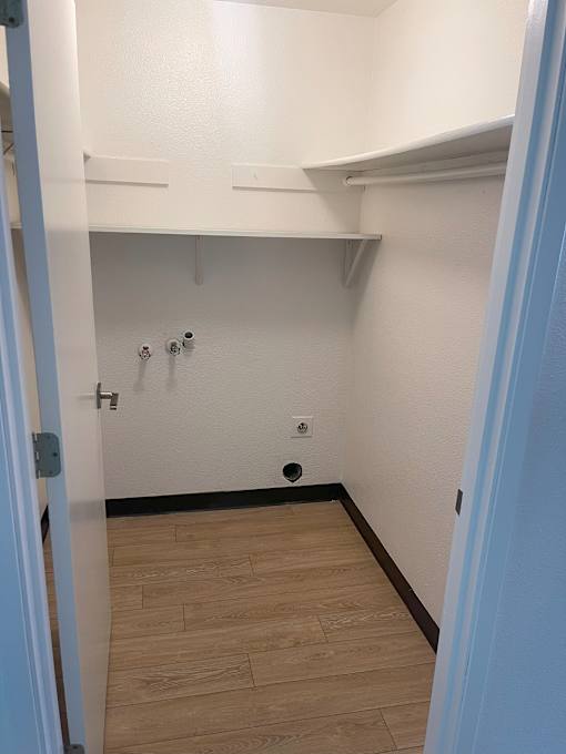 A white hallway with a door on the left.