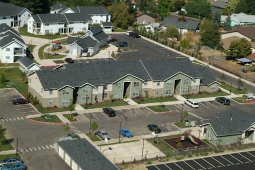 A large group of houses with a parking lot in front.