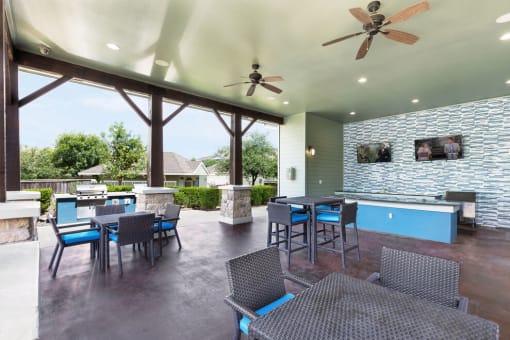 a patio with a fireplace and a bar with chairs and tables