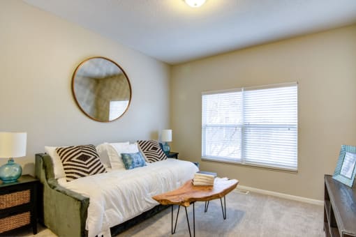 a bedroom with beige walls and a large window