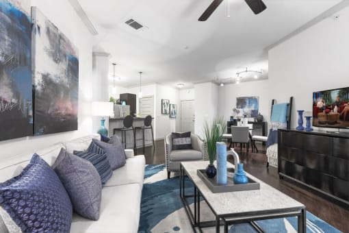 a living room filled with furniture and a ceiling fan
