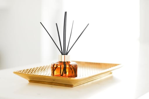 a diffuser sitting on a tray with a black reed diffuser on top of it