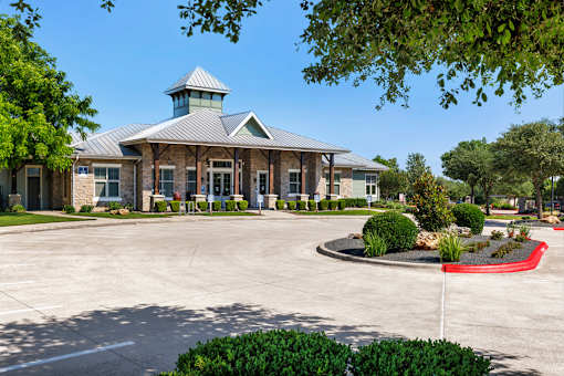 A building with a tower and a circular driveway in front.