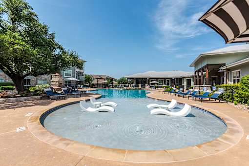 A large swimming pool with a water feature in the middle at 95twenty Apartments, Texas