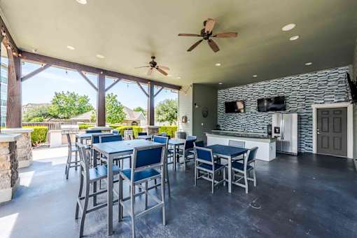 A patio with a table and chairs and a ceiling fan at 95twenty Apartments, Austin, TX, 78717
