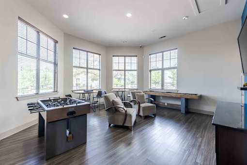 A modern kitchen with a large island and a dining area with chairs at 95twenty Apartments, Austin, Texas