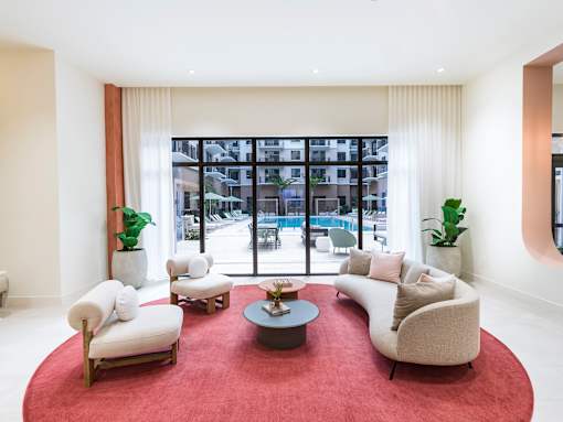 A living room with a red carpet and white furniture.