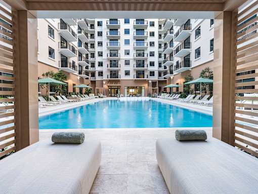 A large indoor swimming pool with a view of a multi-story building.