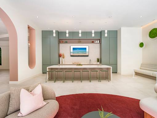 A modern living room with a grey sofa and a red rug.