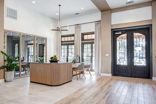 Leasing office with modern interior with a wooden reception desk and a black door. at Barton Creek Villas, Austin, 78735