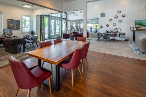 a dining room with a wooden table and red chairs