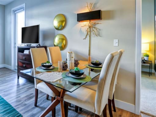 a dining room with a table and chairs and a television in the background