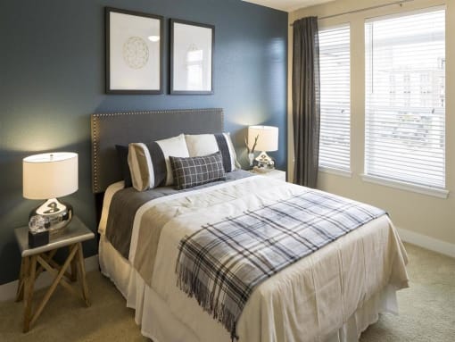 a bedroom with a bed and two windows