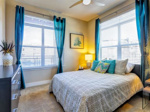 a bedroom with a bed and two windows
