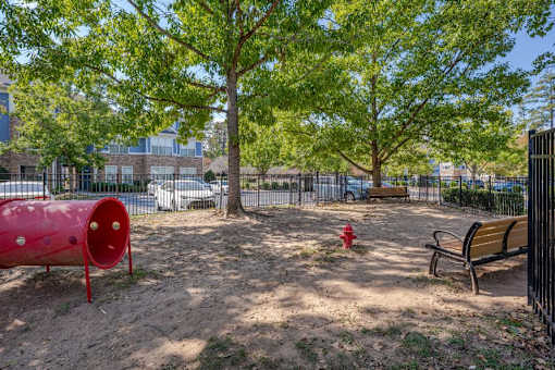 A red fire hydrant sits in the middle of a dirt field.