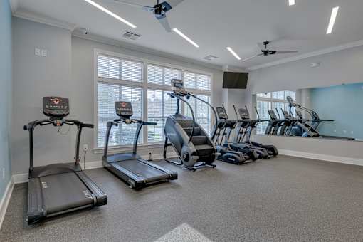 A spacious room with treadmills and elliptical machines.