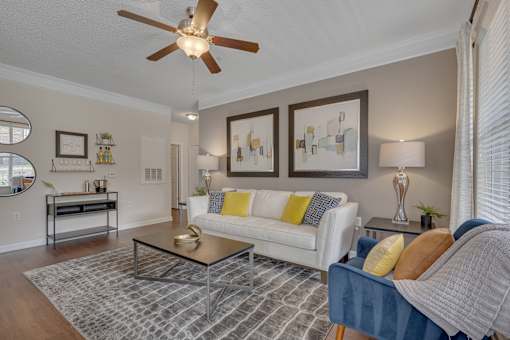 A living room with a white couch and a blue chair.