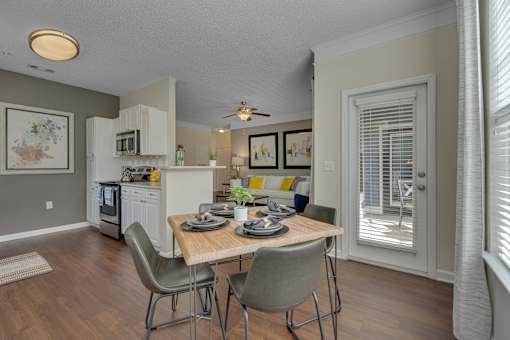 A kitchen with a table and chairs in front of a window.