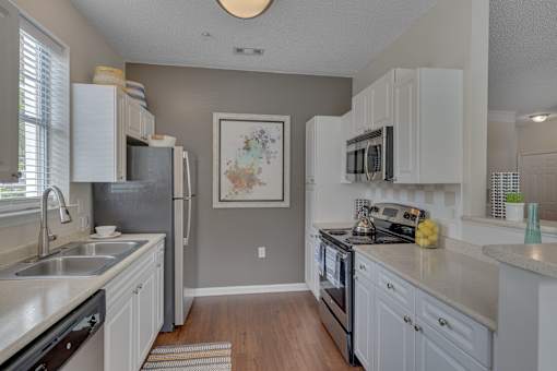 A kitchen with white cabinets and a black stove top oven.