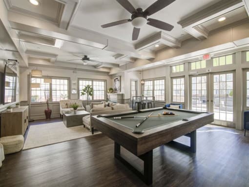 a large room with a pool table and couches