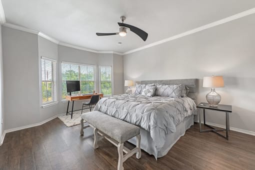 A bedroom with a bed, a chair, and a table with a lamp on it at Barton Creek Villas, Austin.