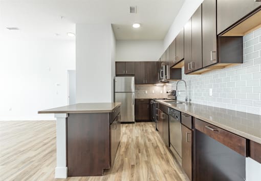 a kitchen with dark wood cabinets and stainless steel appliances at RockVue, Broomfield, 80021