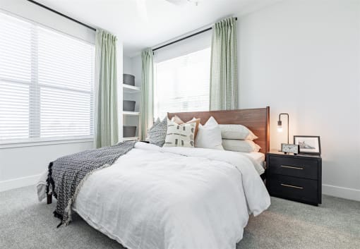 a bedroom with two windows and a bed with a white comforter and pillows at RockVue, Broomfield, 80021