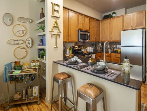 a kitchen with a counter top and stools at Retreat at Shadow Creek Ranch Apartments, Woodburn, TX, 77584