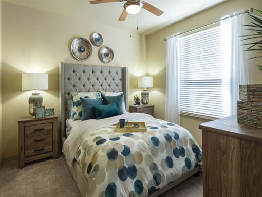 a bedroom with a bed and a ceiling fan at Retreat at Shadow Creek Ranch Apartments, Texas