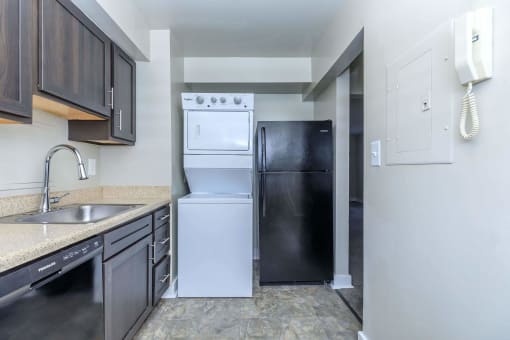 a kitchen with white appliances and black cabinets at Parkland Village, Maryland