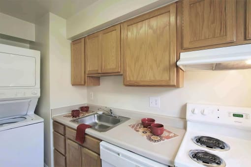 a kitchen with wooden cabinets and white appliances at Parkland Village, Forestville