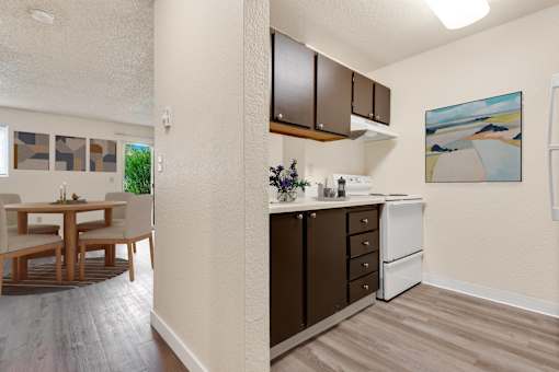 a kitchen and dining room area with a table and chairs and a wall at Eagles Landing Apartments, Washington