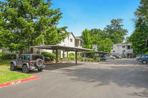 a parking lot with a jeep parked in front of a house at Sage Apartments, Everett, Washington