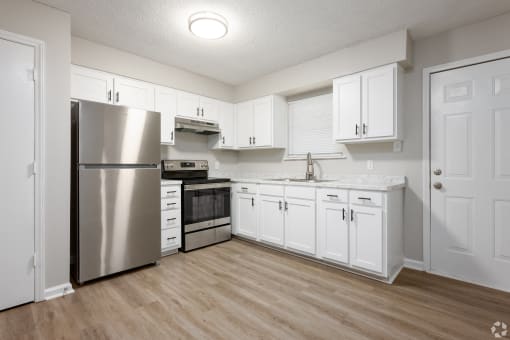 a white kitchen with stainless steel appliances and white cabinets