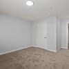 A room with a carpeted floor and a white door.