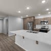A white countertop with a sink and a refrigerator in the background.