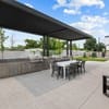 A patio with tables and chairs under a roof.