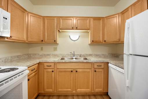 A kitchen with wooden cabinets and a white refrigerator.