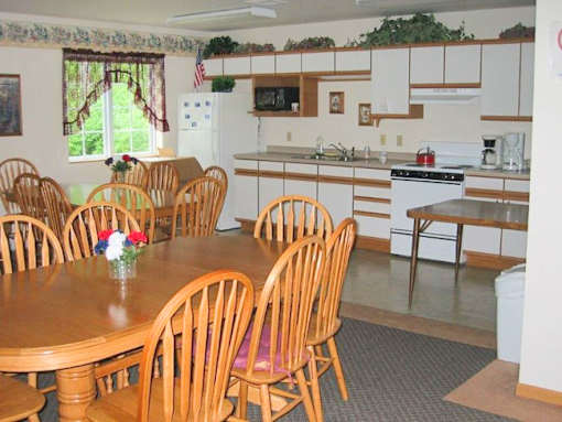 A kitchen with a table and chairs in front of it.