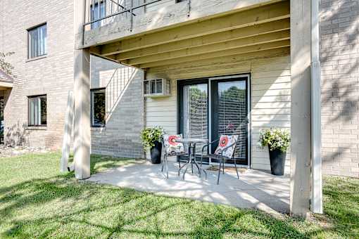 A patio with a table and chairs is in front of a building.