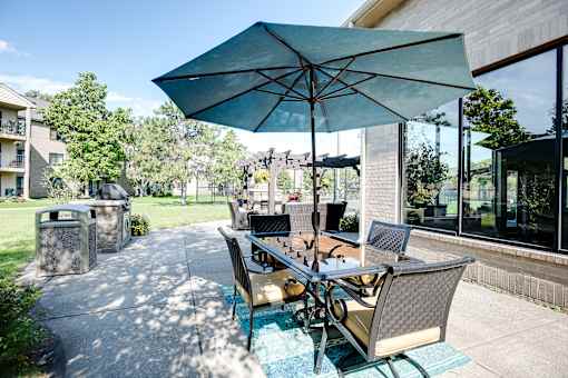 A patio with a table and chairs under an umbrella.