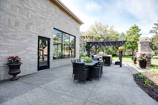 A patio with a table and chairs is surrounded by a brick wall.