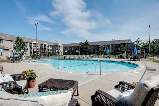 A pool surrounded by chairs and umbrellas.