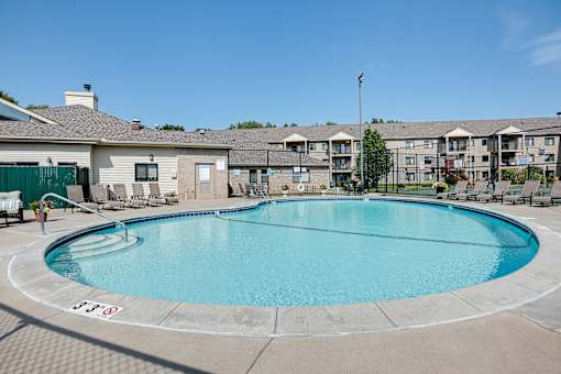 A large swimming pool in front of apartment buildings.