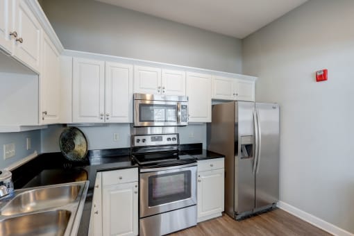 a kitchen with stainless steel appliances and white cabinets