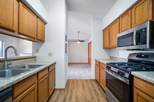 a kitchen with wooden cabinets and stainless steel appliances